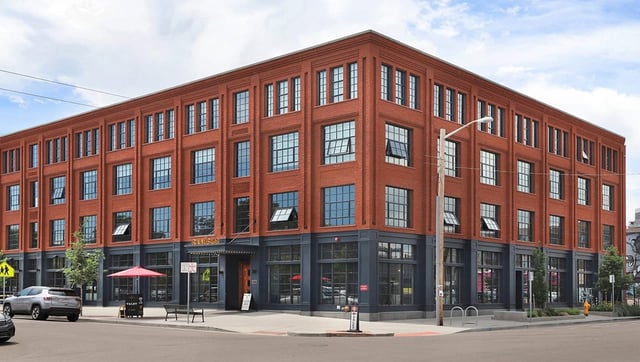 corner-view-of-a-multi-story-red-brick-building-featuring-large-industrial-style-windows-and-storefront-glazing